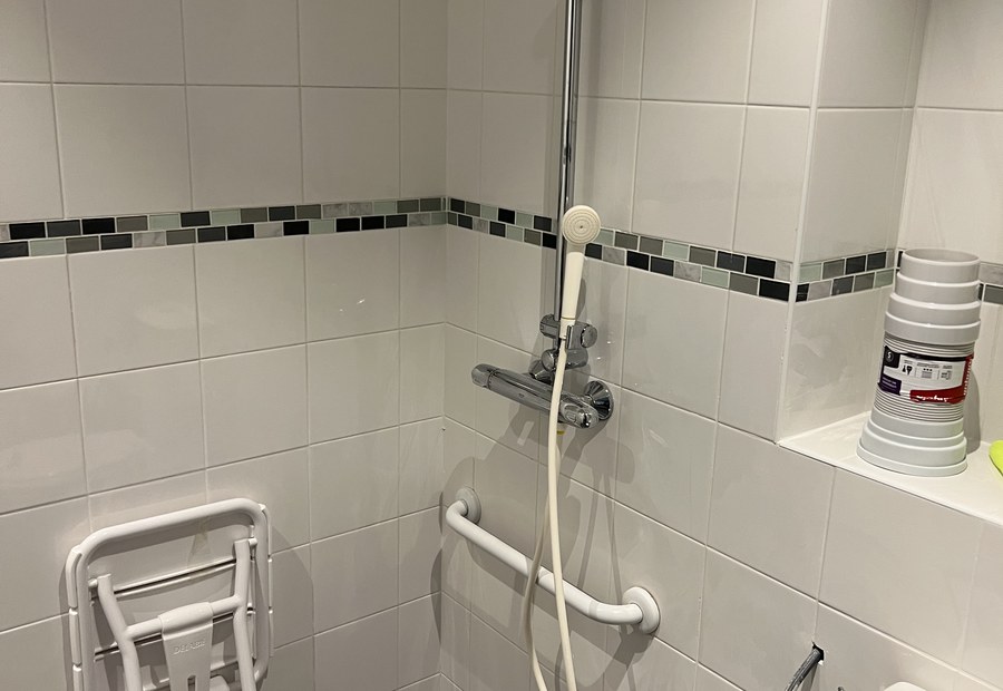 Salle de bain adaptée PMR — barre d'appui, douche thermostatique, siège escamotable